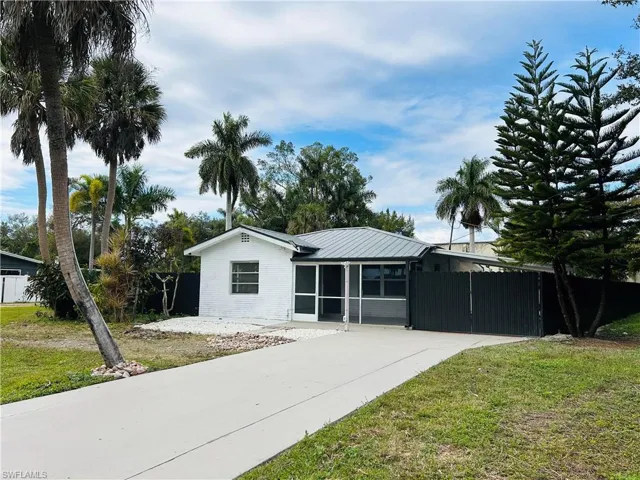 Ranch-style house with a gate, a sunroom, and a metal roof