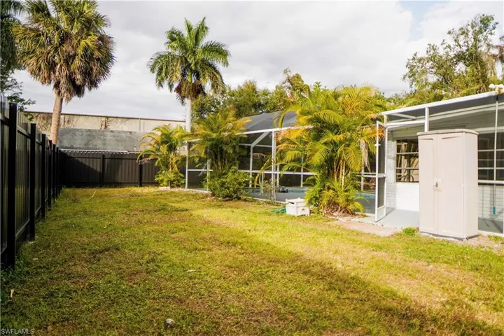 Fenced backyard with glass enclosure and a sunroom