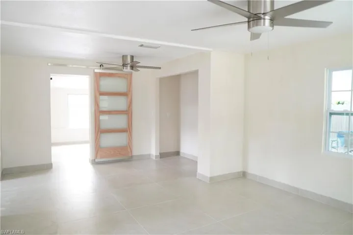 Unfurnished room featuring ceiling fan and baseboards