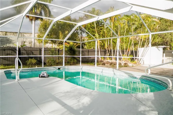 View of pool featuring a lanai, a fenced backyard, and a sunroom