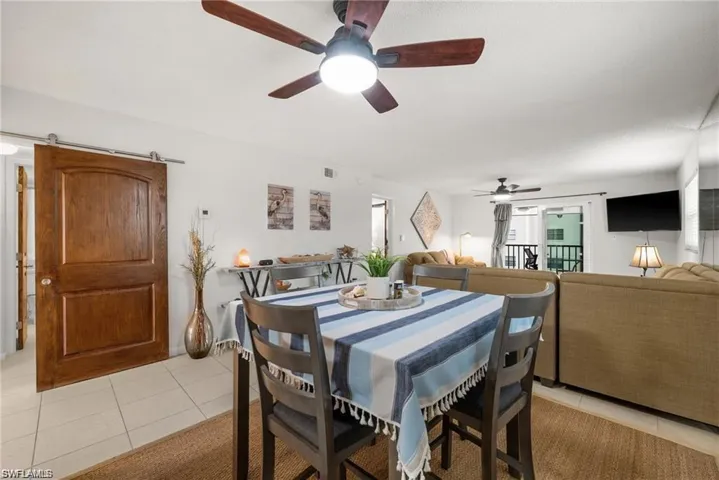 Dining room with a barn door and light tile patterned floors