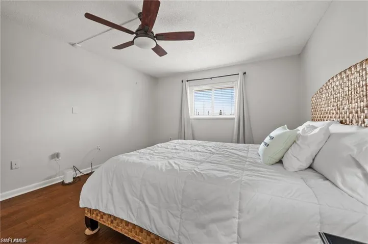 Bedroom featuring wood finished floors, a textured ceiling, and ceiling fan