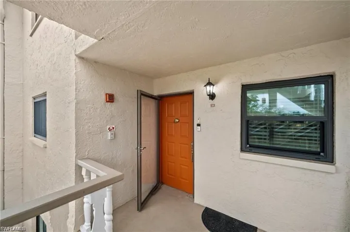 Doorway to property featuring stucco siding