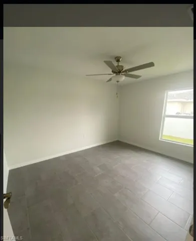 Unfurnished room featuring baseboards and a ceiling fan
