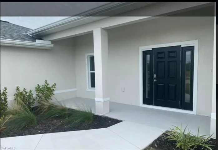 Property entrance with stucco siding and covered porch
