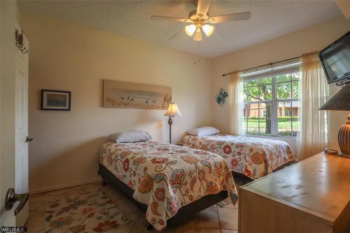 Tiled bedroom with a textured ceiling and ceiling fan