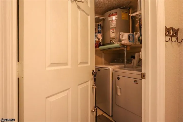 Laundry room featuring washing machine and clothes dryer, water heater