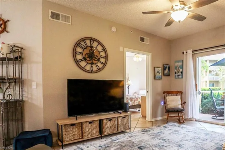 Living room featuring a ceiling fan, tile patterned floors