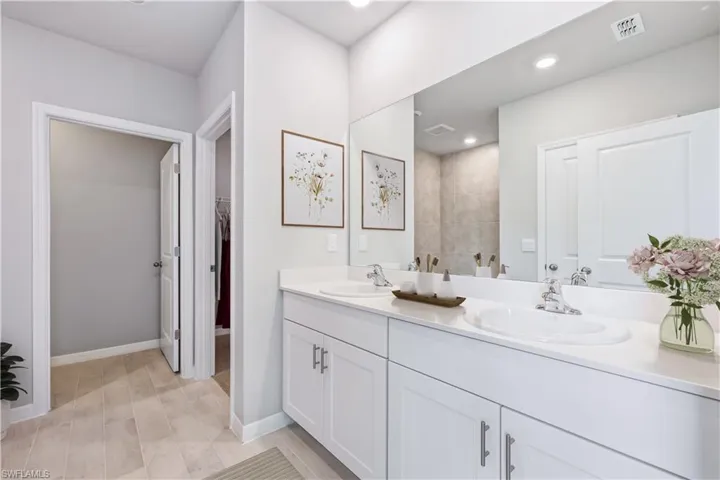 Bathroom with tiled shower and vanity