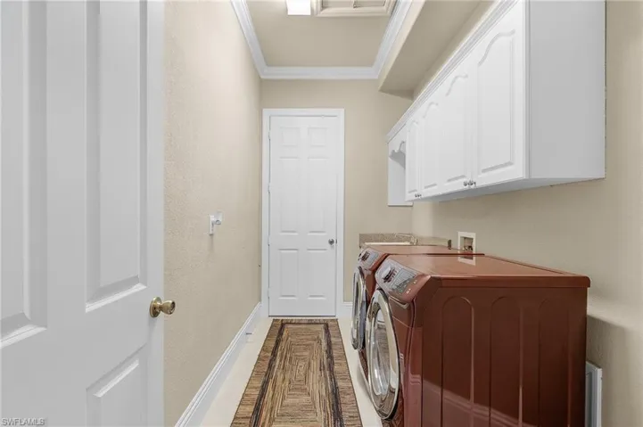 Laundry tub, overhead cabinets and front loading washer & dryer