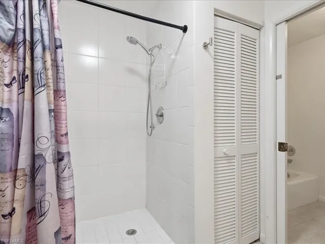 Full bathroom with a stall shower and a closet