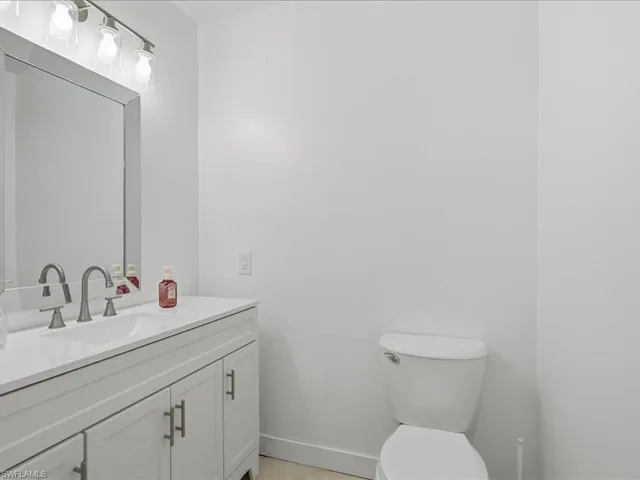 Half bathroom featuring vanity and toilet
