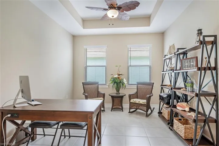 Tiled home office with a tray ceiling and ceiling fan