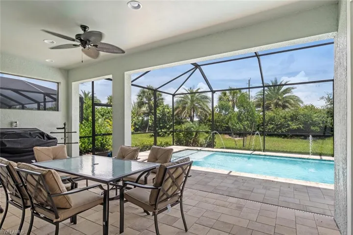 View of swimming pool featuring a patio, pool water feature, a lanai, and ceiling fan