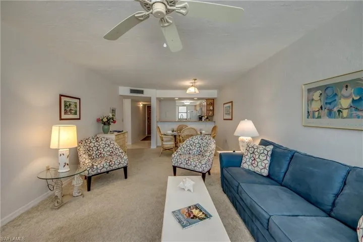 Open concept living area featuring textured ceilings, neutral carpeting, and a ceiling fan