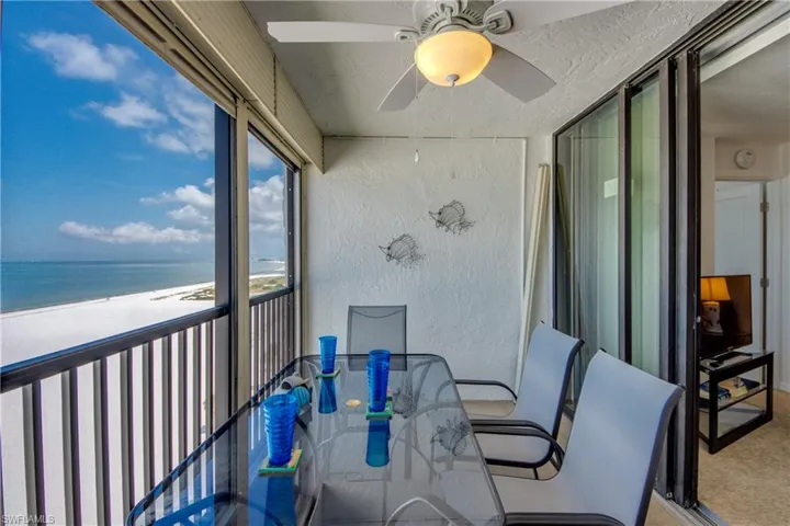 Screened balcony with panoramic white sand beach and ocean scenery