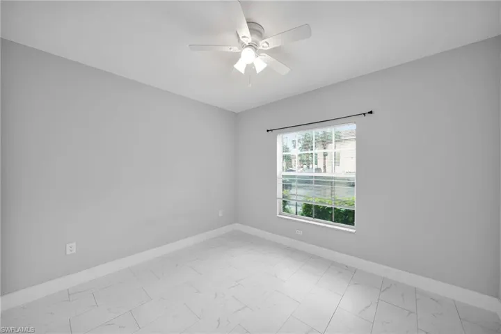 Tiled empty room with ceiling fan