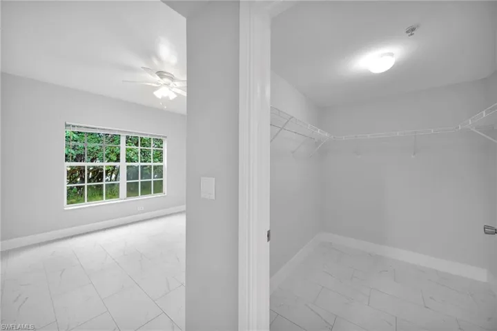 Spacious closet featuring ceiling fan and light tile patterned floors