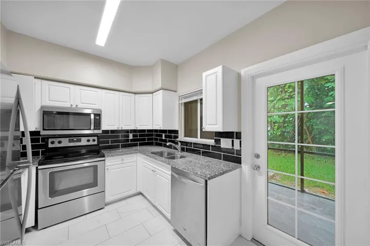 Kitchen featuring sink, tasteful backsplash, light tile patterned floors, and stainless steel appliances
