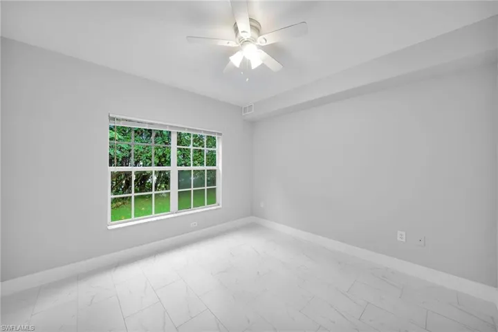 Unfurnished room with light tile patterned floors and ceiling fan