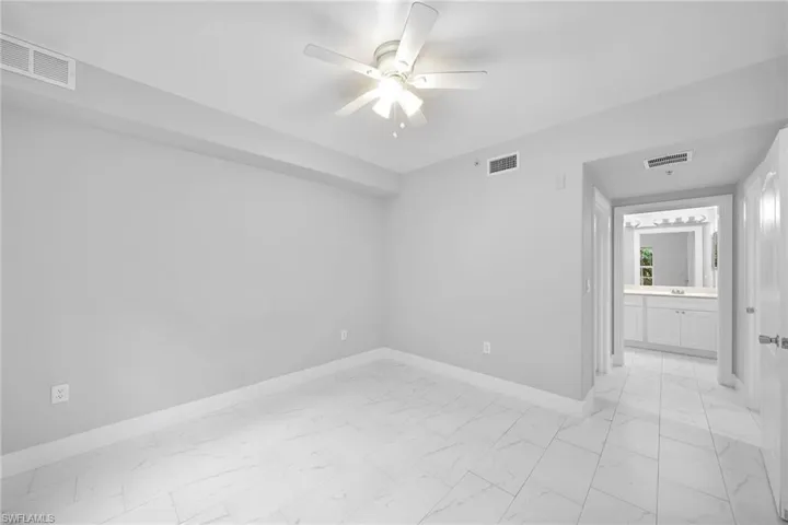 Empty room with light tile patterned flooring and ceiling fan