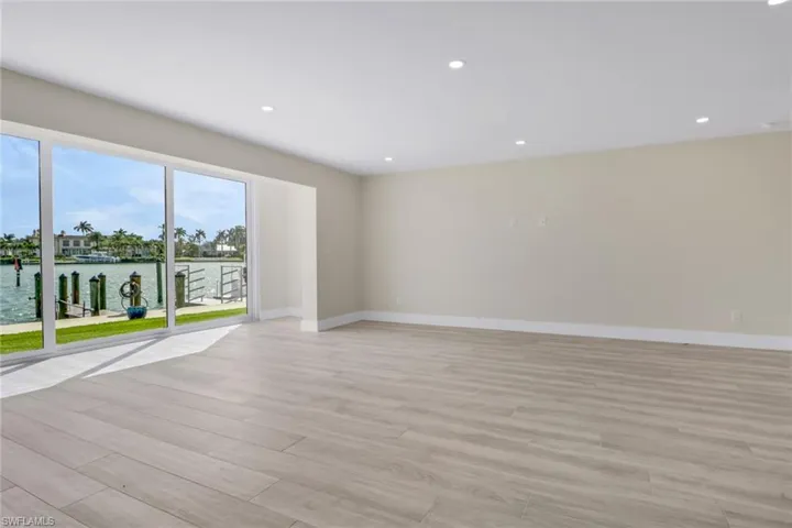 Spare room featuring a water view, light wood-type flooring, and recessed lighting