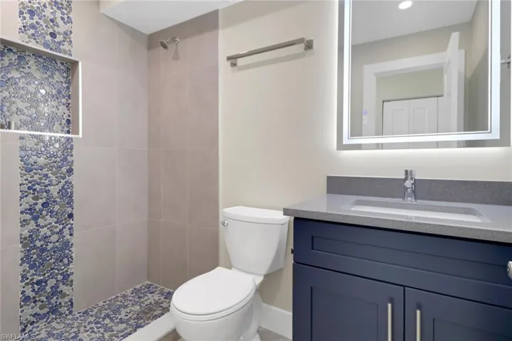 Full bathroom featuring vanity and tiled shower