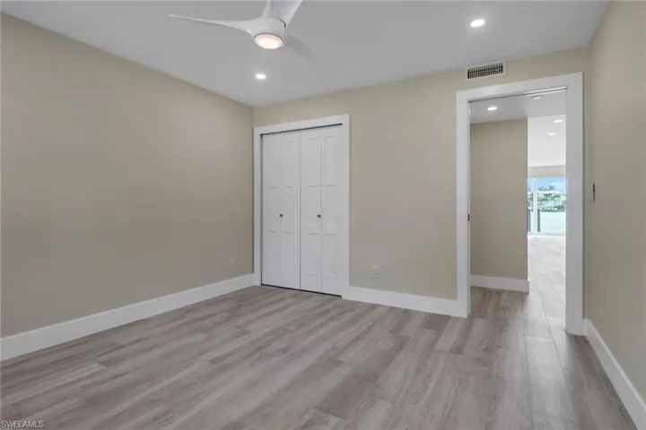 Unfurnished bedroom featuring light wood-style flooring, recessed lighting, a ceiling fan, and a closet