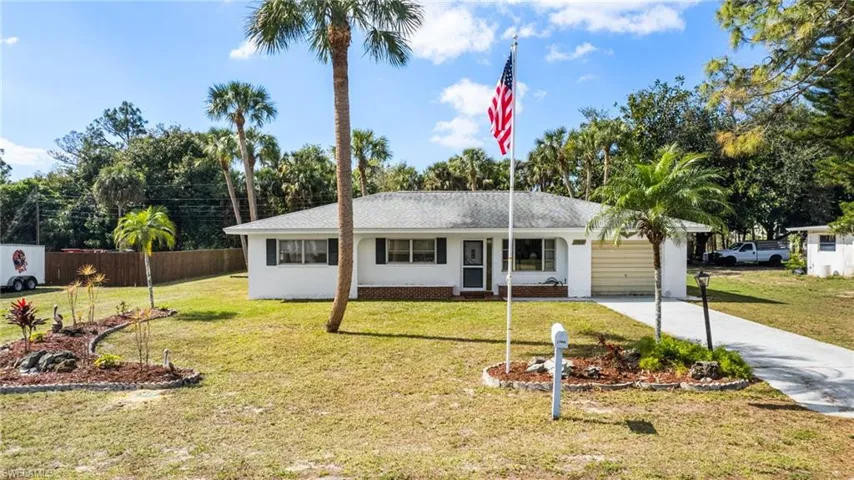 Ranch-style home with a front yard and a garage