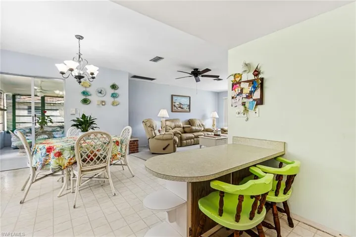 Dining space with ceiling fan with notable chandelier
