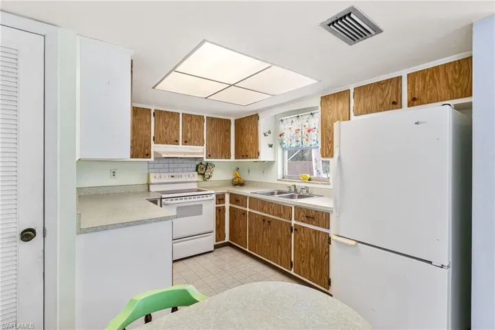 Kitchen featuring white appliances and sink