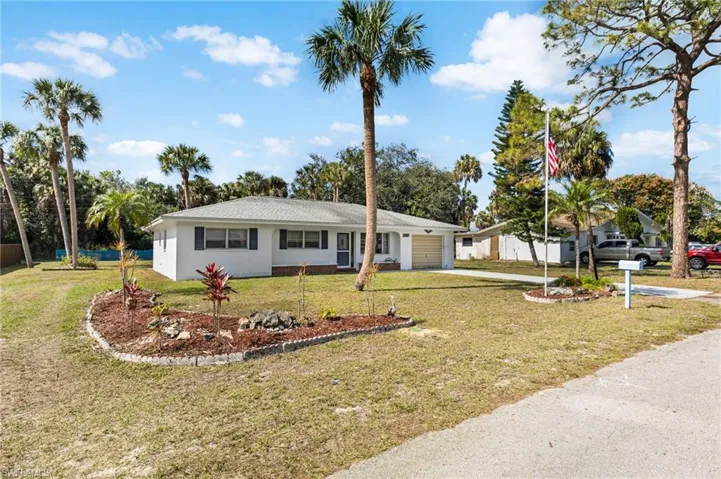 Ranch-style home with a garage and a front lawn