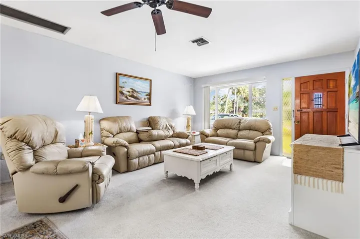 Living room with light colored carpet and ceiling fan