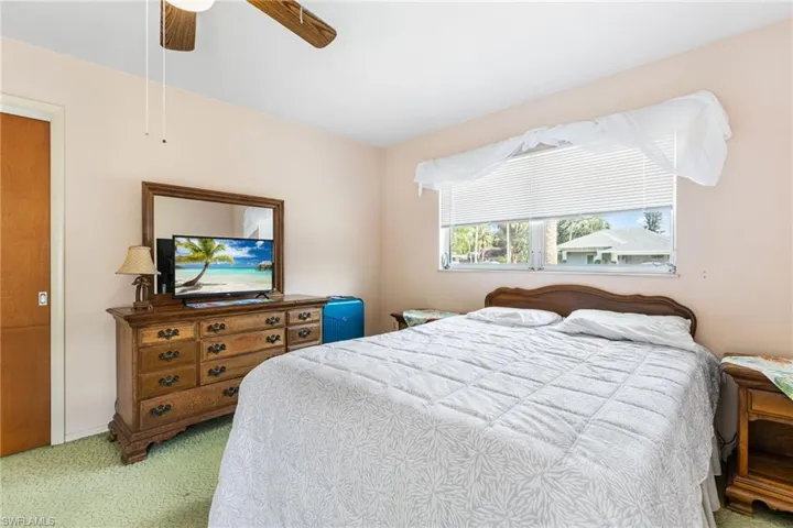 Bedroom with ceiling fan and light colored carpet