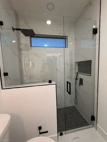 Bathroom featuring a marble finish shower and marble finish floors