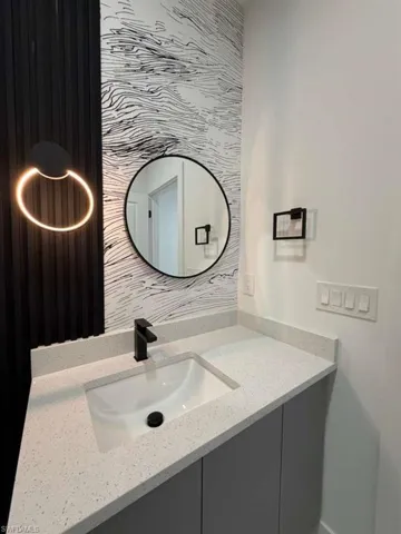 Bathroom with vanity and tasteful backsplash