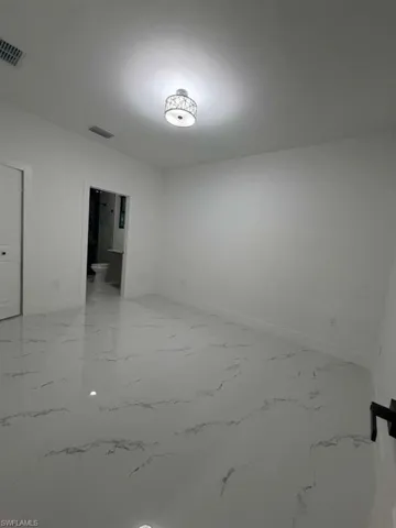 Unfurnished room featuring baseboards and light marble finish flooring