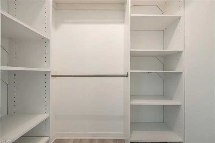 Walk in closet with wood finished floors