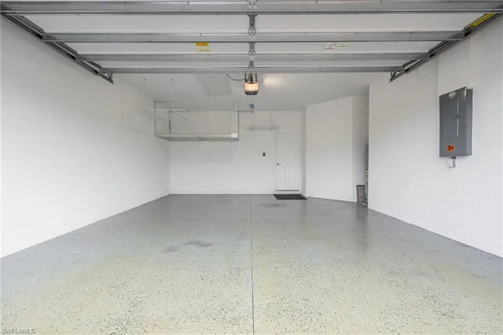 Garage featuring electric panel and a garage door opener