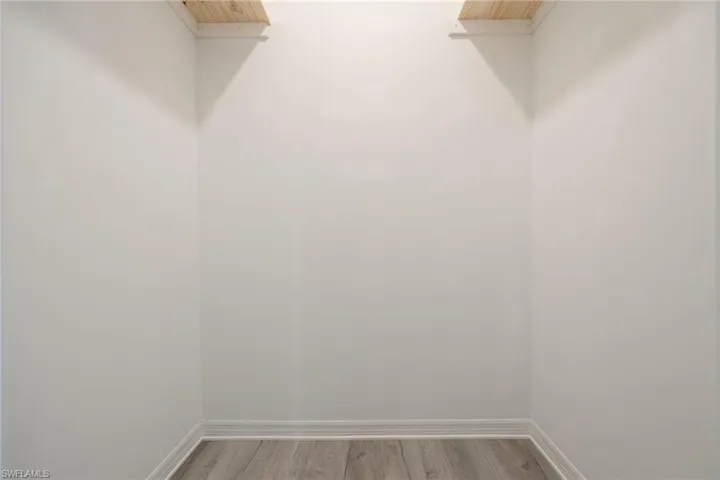 Walk in closet with wood finished floors