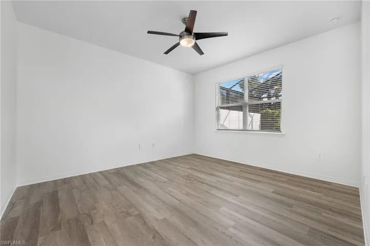 Spare room with light wood-style floors, baseboards, and a ceiling fan