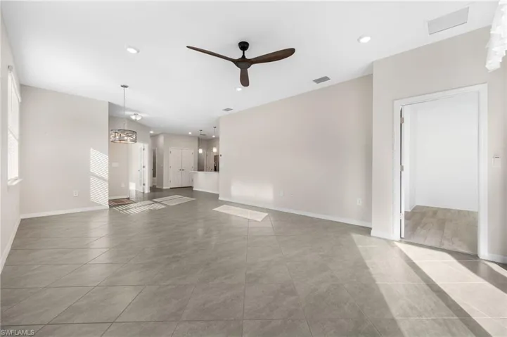 Unfurnished living room featuring baseboards, visible vents, a ceiling fan, and recessed lighting