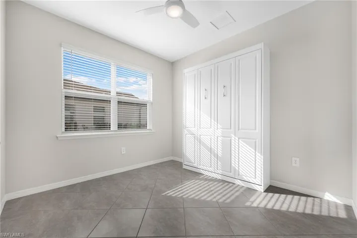 Unfurnished bedroom featuring light tile patterned floors, visible vents, baseboards, a ceiling fan, and a closet