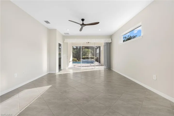 Empty room with baseboards, visible vents, a ceiling fan, a sunroom, and light tile patterned flooring