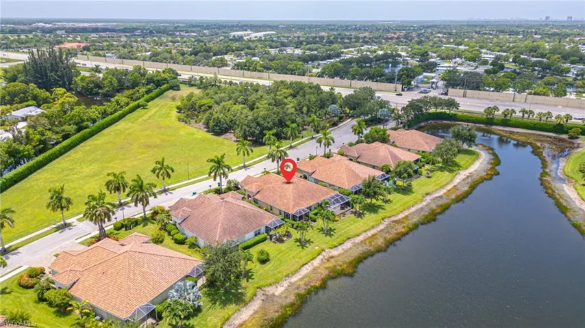 Aerial view showcasing a waterfront property with a terracotta-style roof