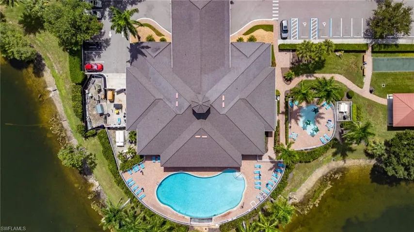 Waterfront community building featuring an expansive outdoor pool deck, a large swimming pool, and a separate wading pool