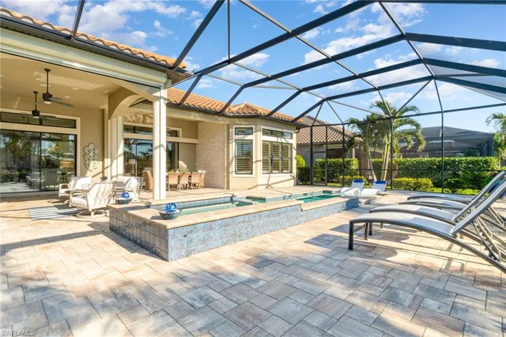 View of swimming pool featuring an in ground hot tub, a patio, glass enclosure, and ceiling fan