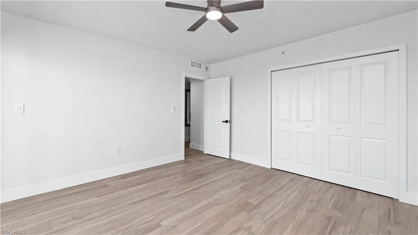 Unfurnished bedroom featuring light wood-style flooring, a closet, and a ceiling fan