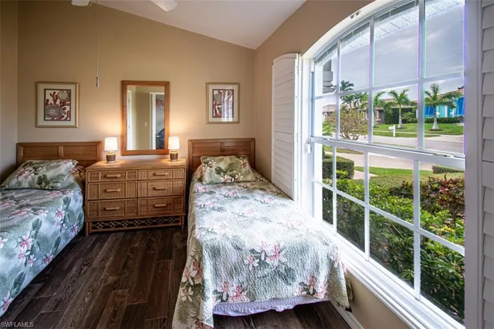 Bedroom with lofted ceiling, dark wood-type flooring, and a ceiling fan