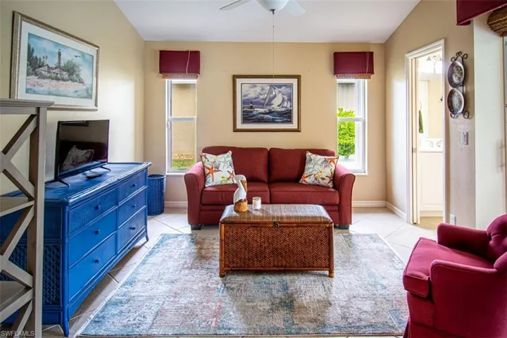Living room with tile patterned flooring, healthy amount of natural light, and ceiling fan